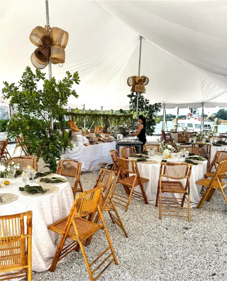 Elegant clearwater FL tent rental for a corporate event under a large 30X50 pole tent with white tablecloths and wooden chairs.